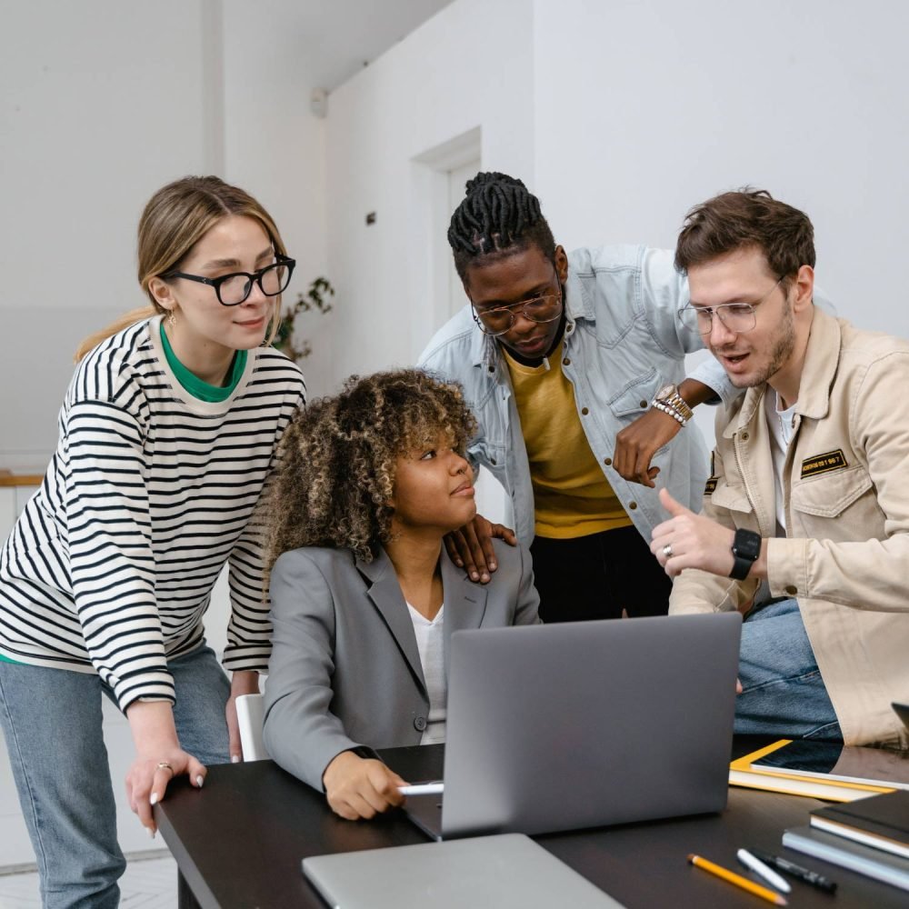 Équipe de jeunes professionnels réunie autour d'un ordinateur portable